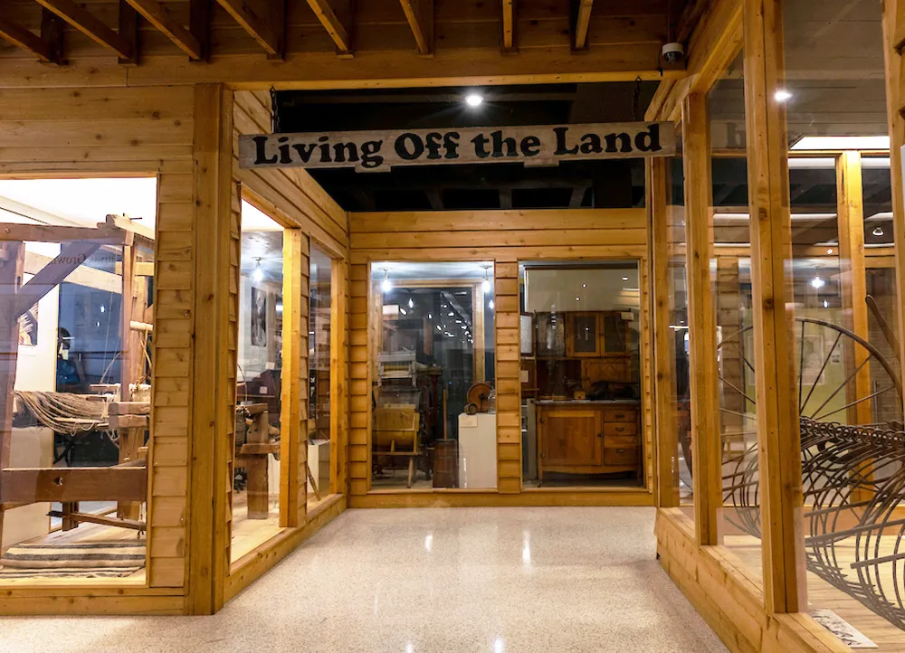 rustic exhibit showing tools used by farmers and early settlers
