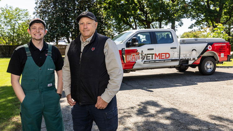 Two men standing in front of a truck
