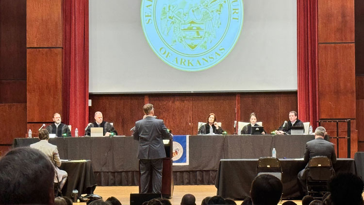 A man stands in frong of the justices