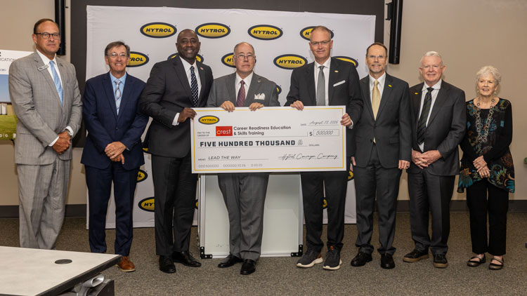People standing holding a large check.