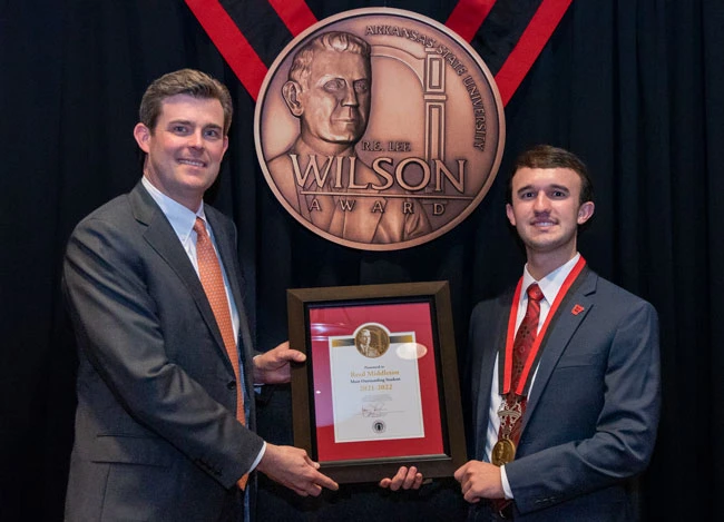 Reed Middleton (right) of Marianna accepts the 2022 Wilson Award from Perry Wilson, great-great-grandson of  R.E. Lee Wilson, for whom Arkansas State University's highest award for a graduating student is named.