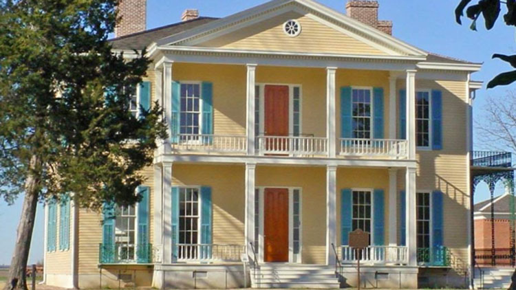 photo of a yellow house with blue shutters