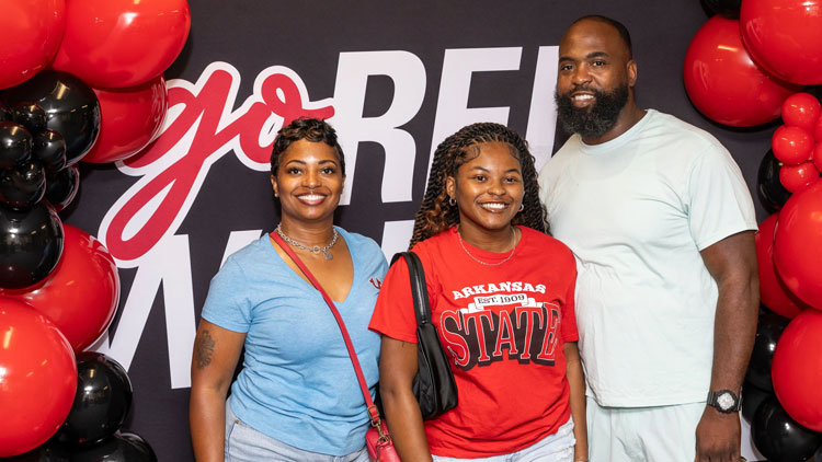 A-State student posing with her family on campus.