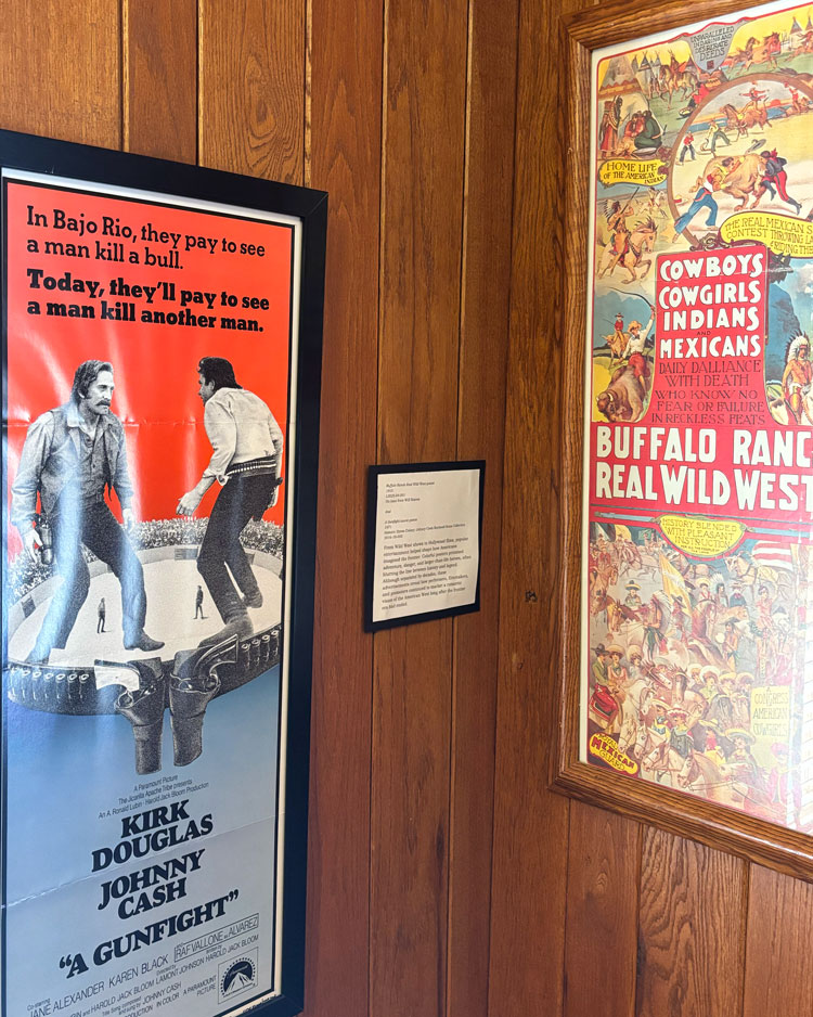 Two posters hang on a wall.