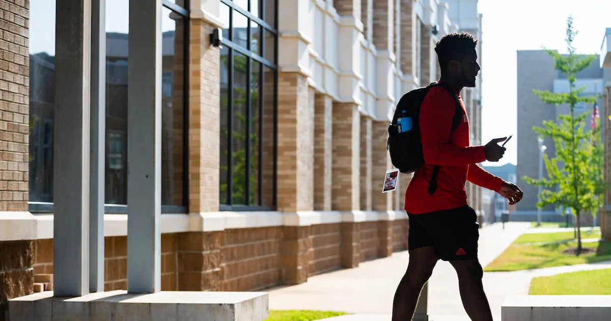 A student walks ahead from the parking deck to the student union
