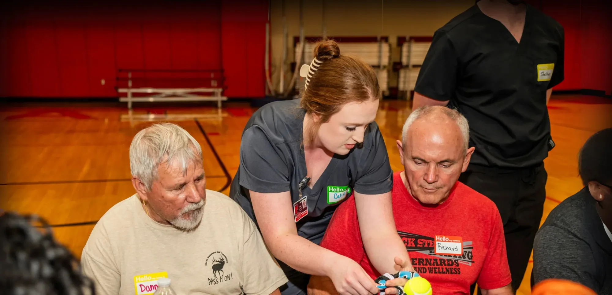 A-State occupational therapist student helping seniors in a gym.
