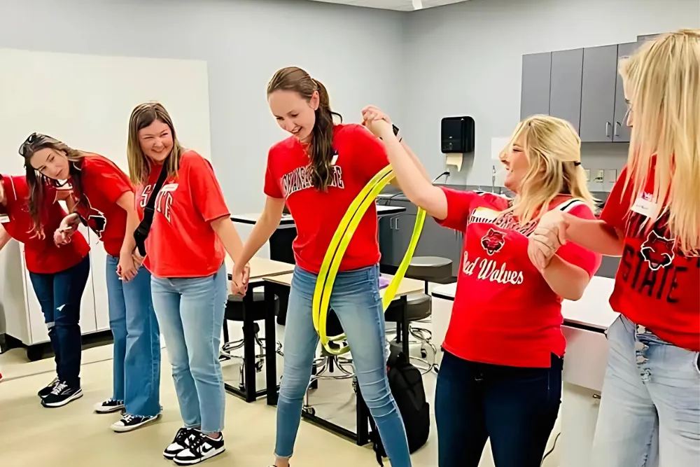 A-State occupational therapy students smiling at a booth at an event.