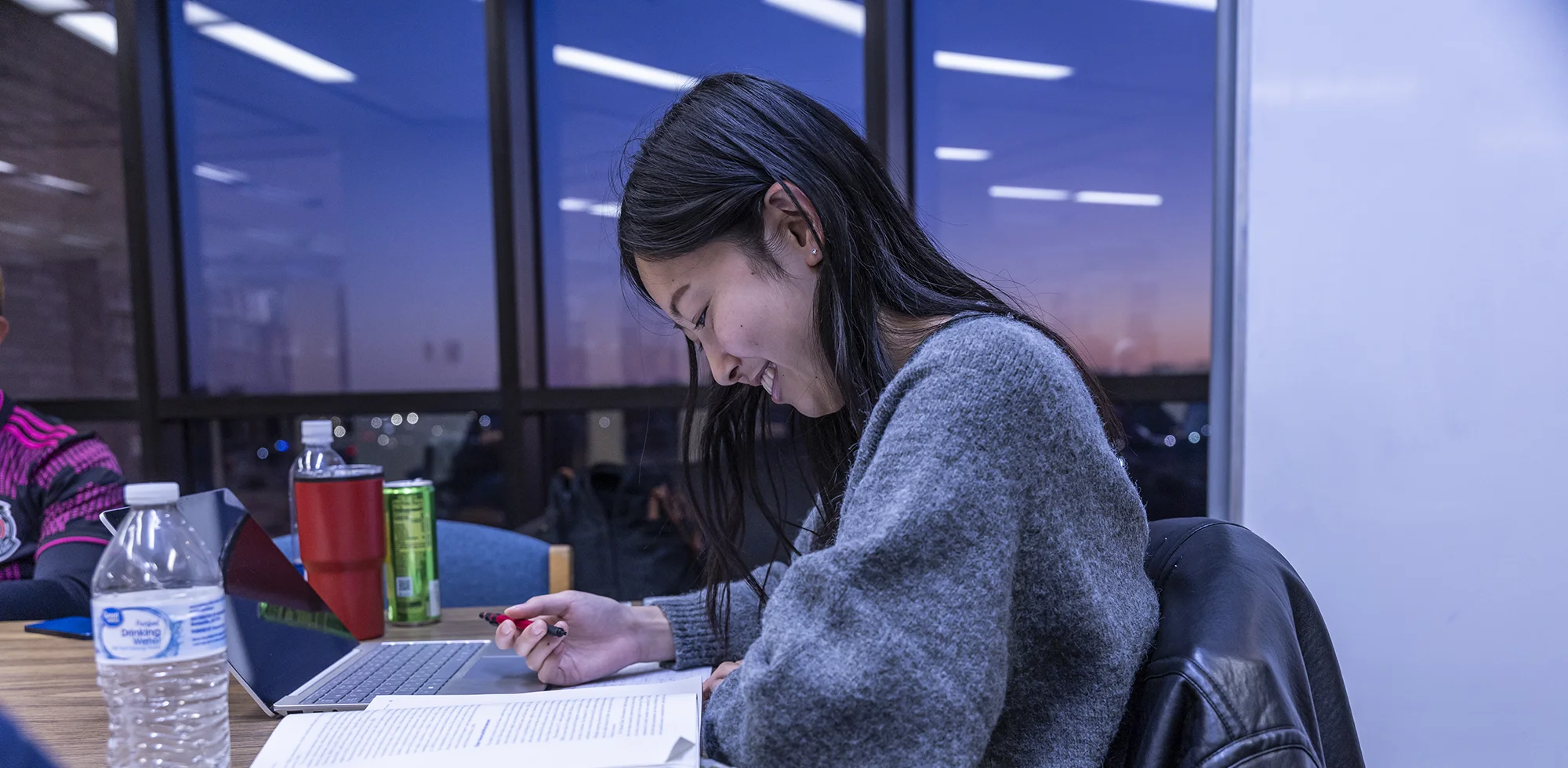 A student smiling as she studies.