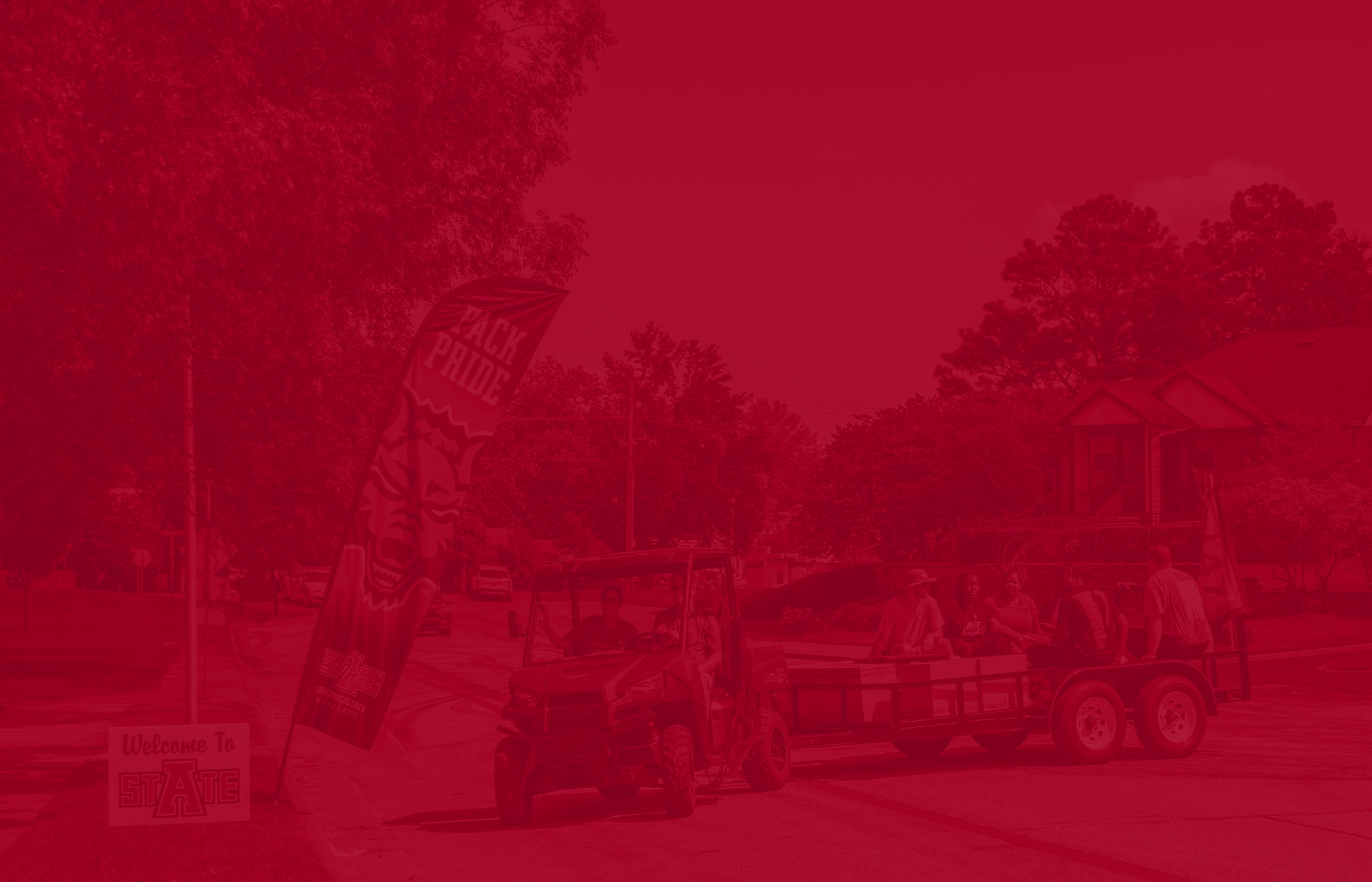 Four wheeler pulling trailer with students and furniture