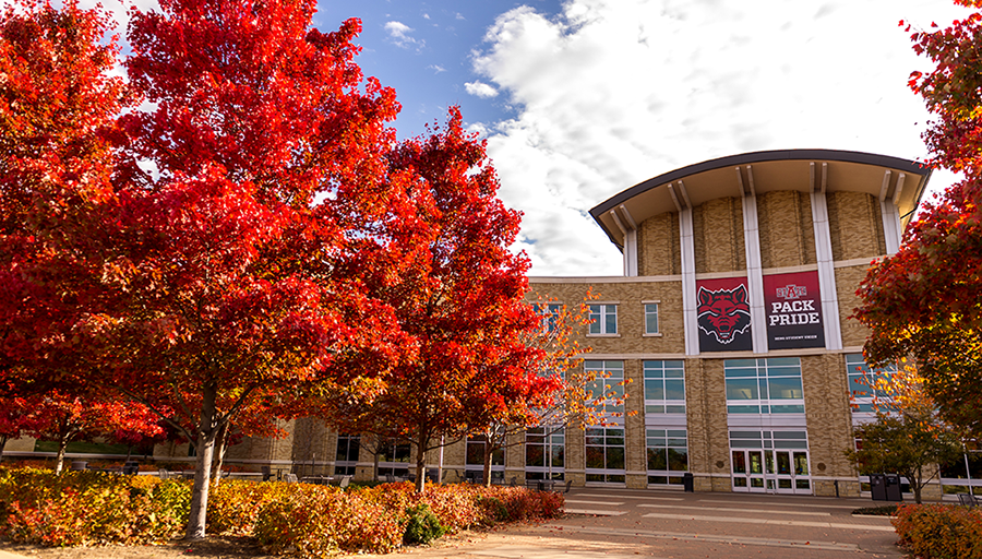 a view of the Reng Student Union, framed by colorful tree foliage