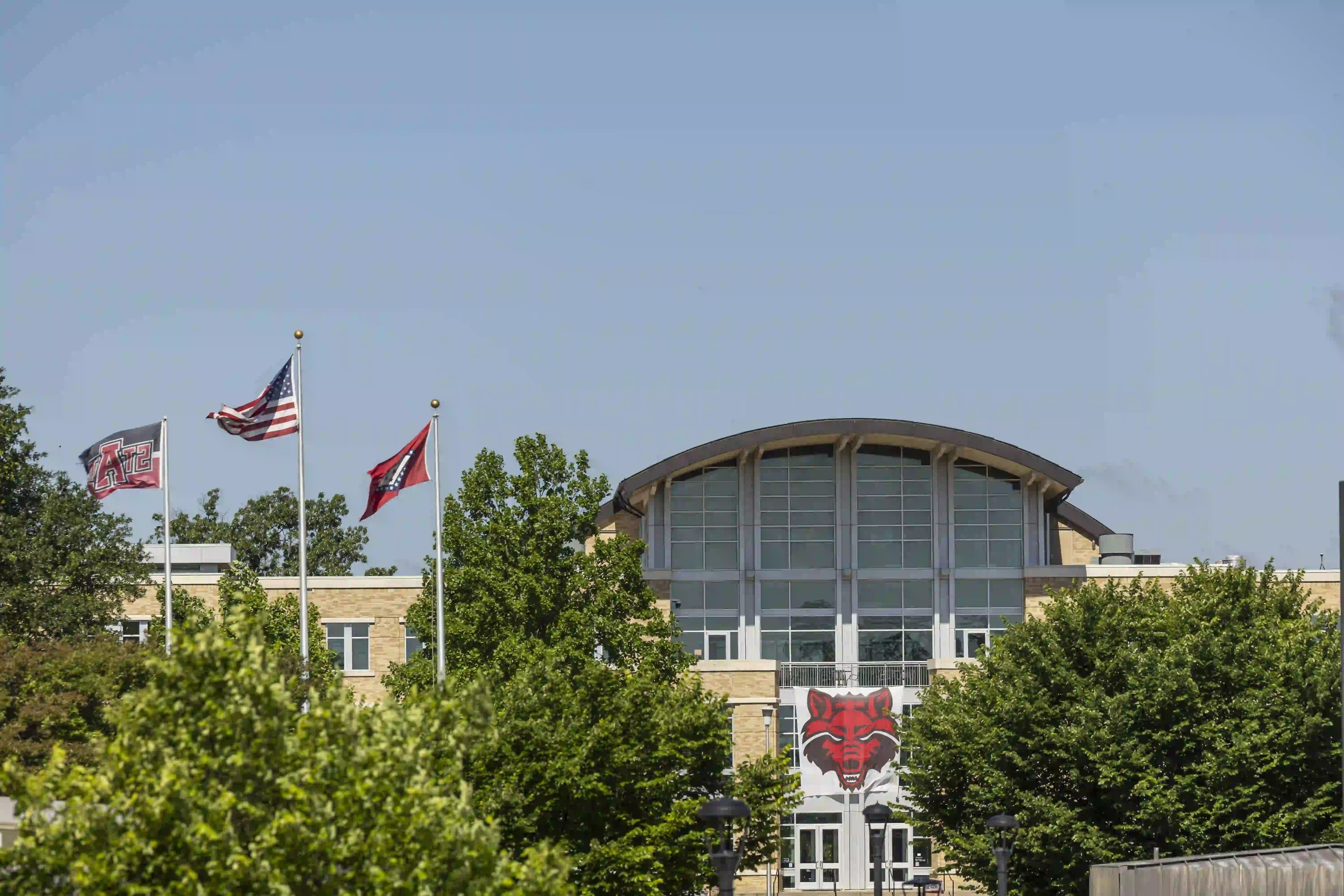 Reng Student Union building with trees and flags in front.