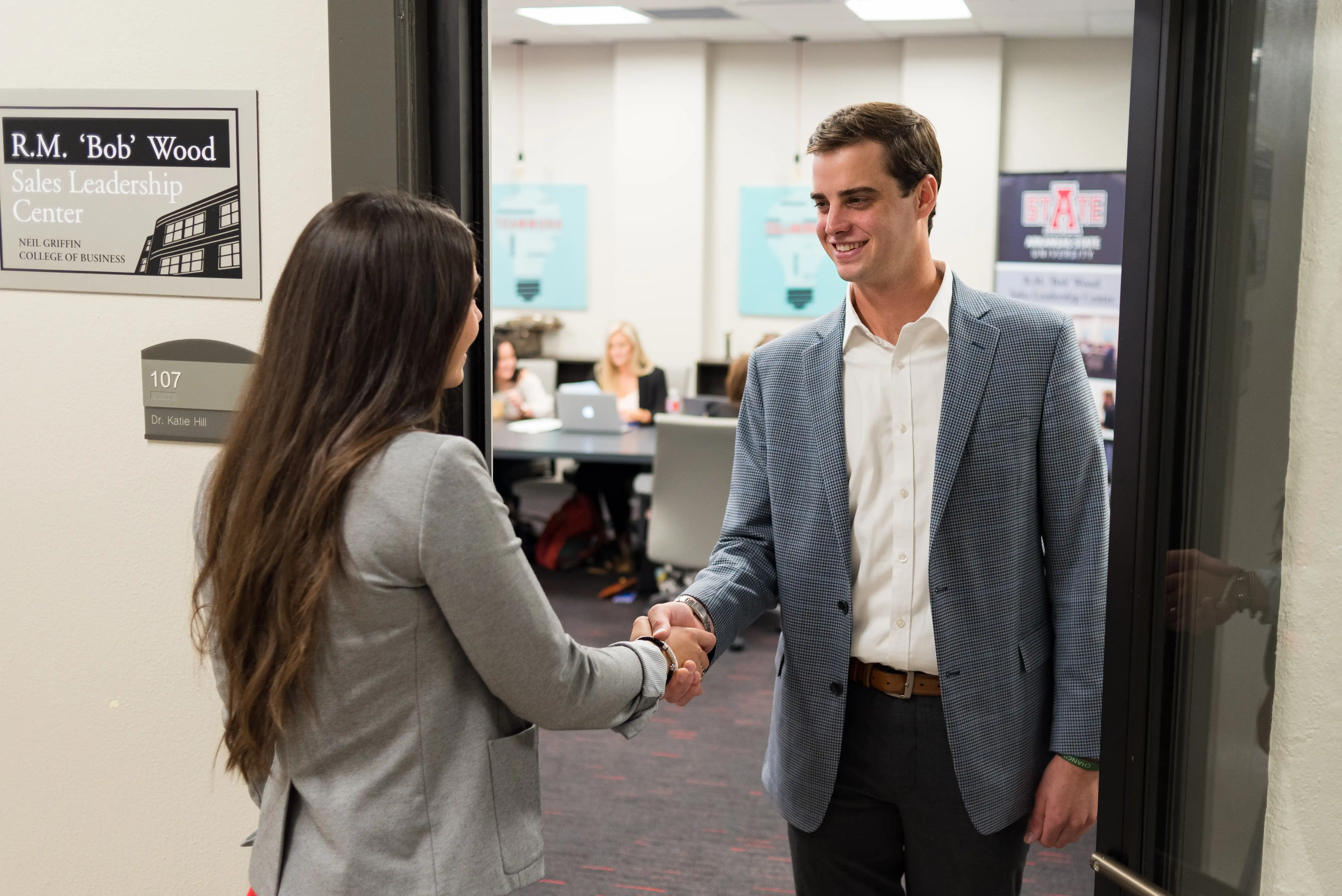 A-State business students shaking hands.