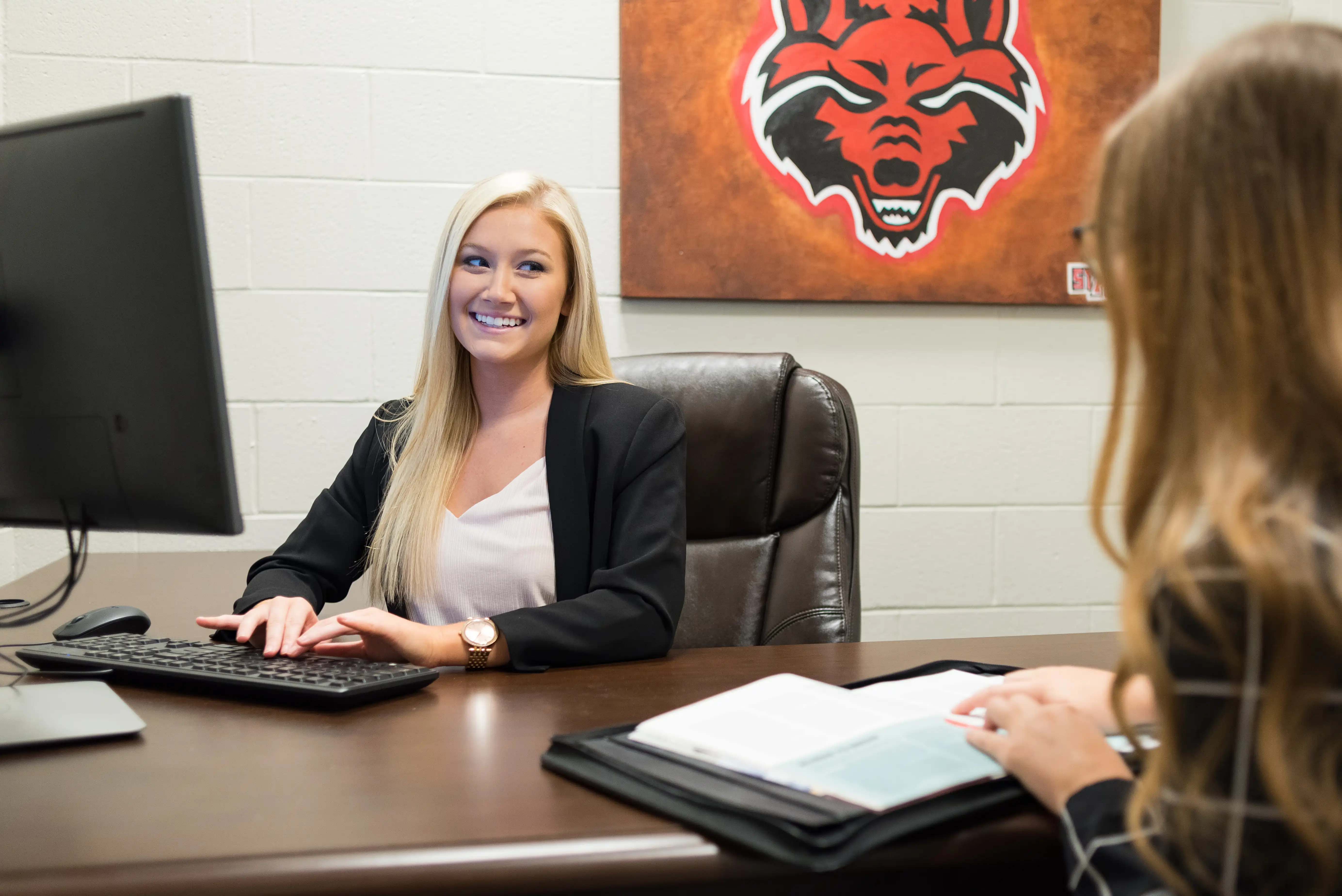 A-State student in sales center performing a mock business meeting.