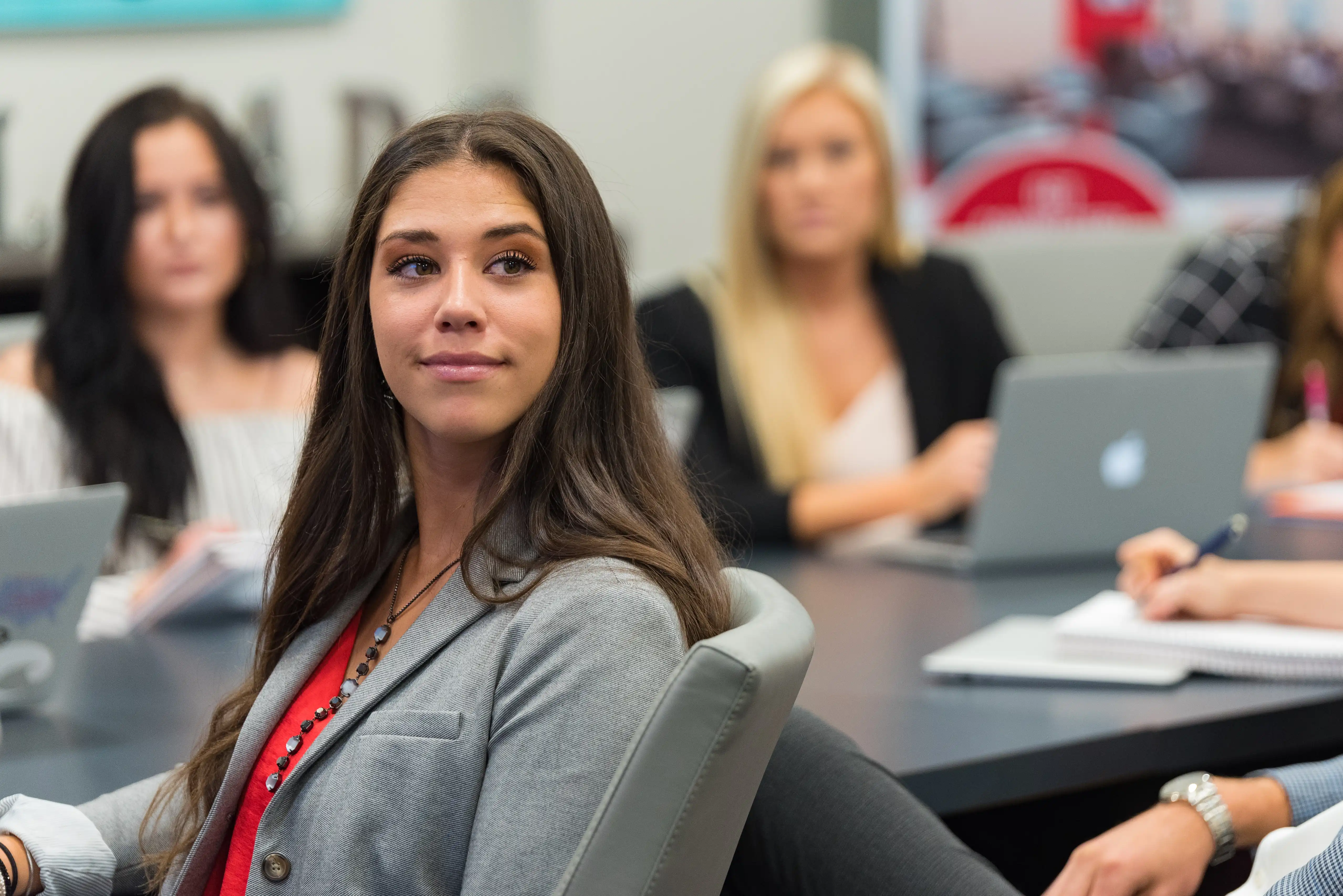 Sales Leadership student facing speaker with other students blurry in the background.