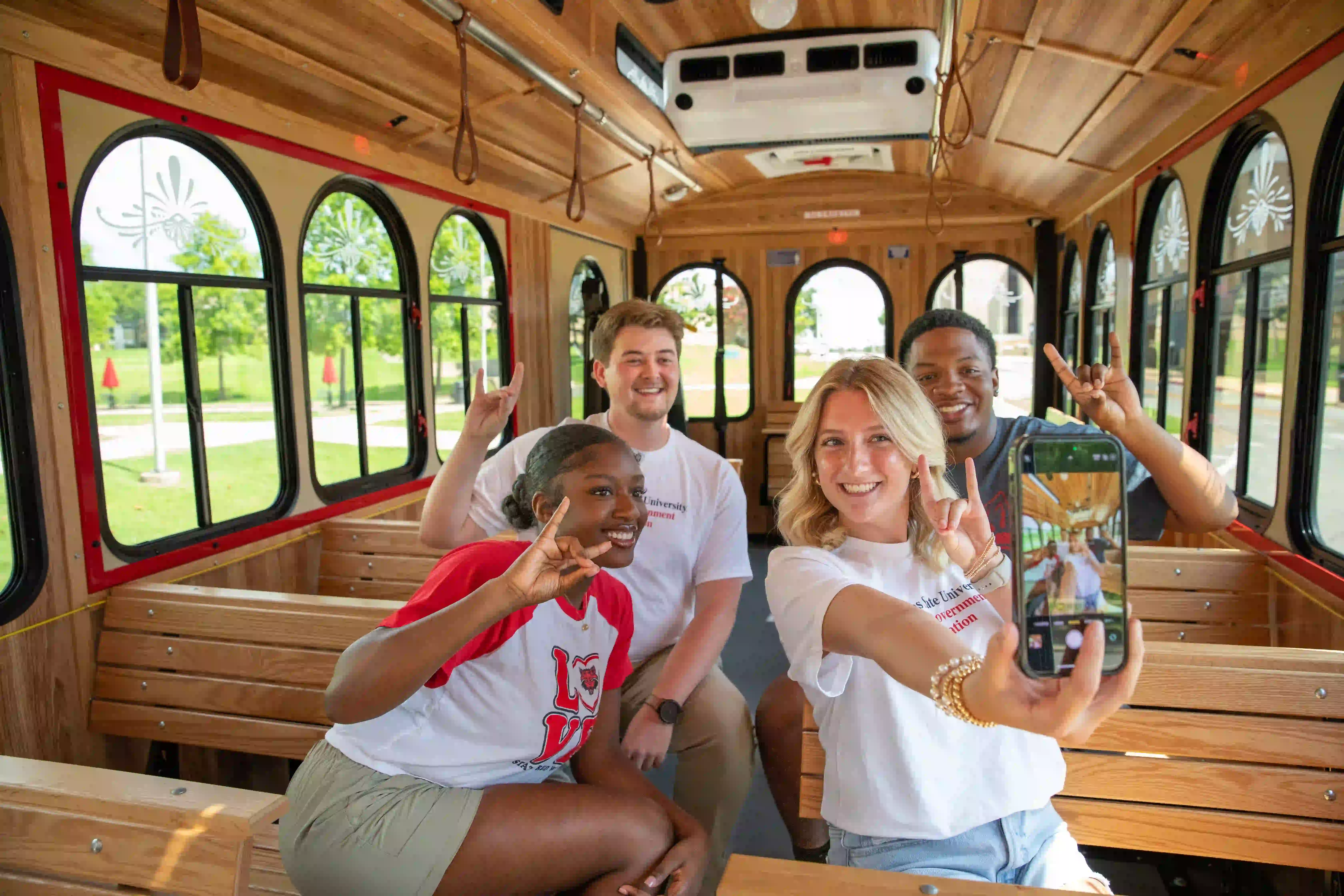 Students taking selfie in trolley.