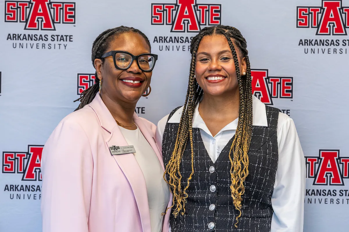 An A-State faculty member takes a photo with a student at the Wilson Award ceremony.