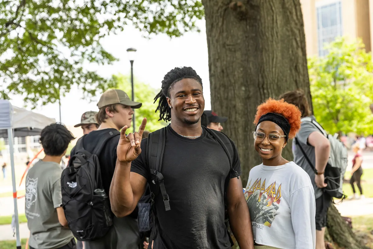 Undergraduate students pose with their Wolves Up for a photo on A-State’s Heritage Plaza Lawn.