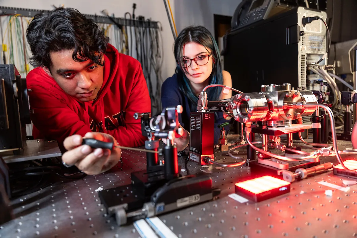 Students conduct a physics experiment in a campus lab.