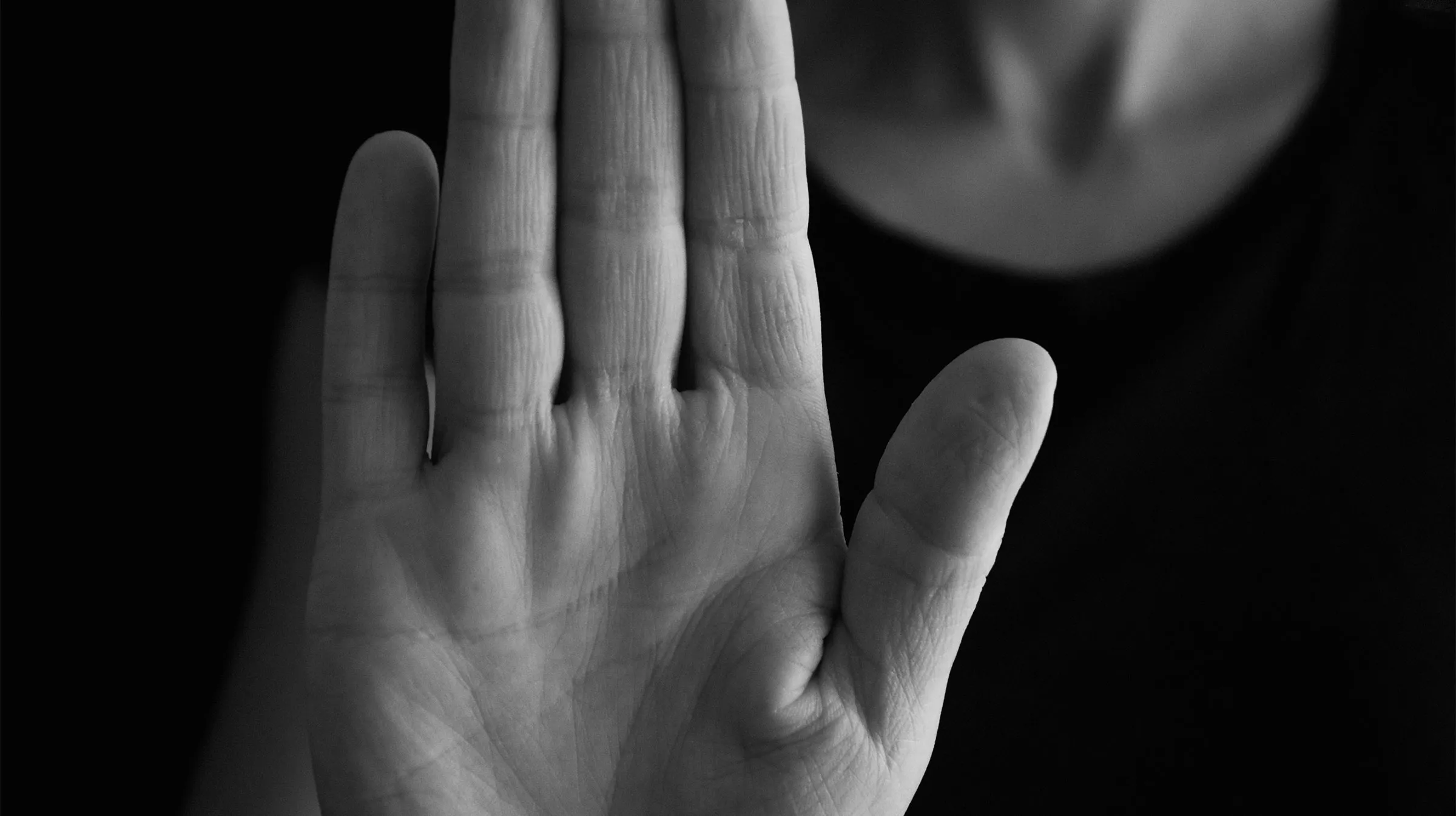 image of a person holding up a hand in the "stop" position