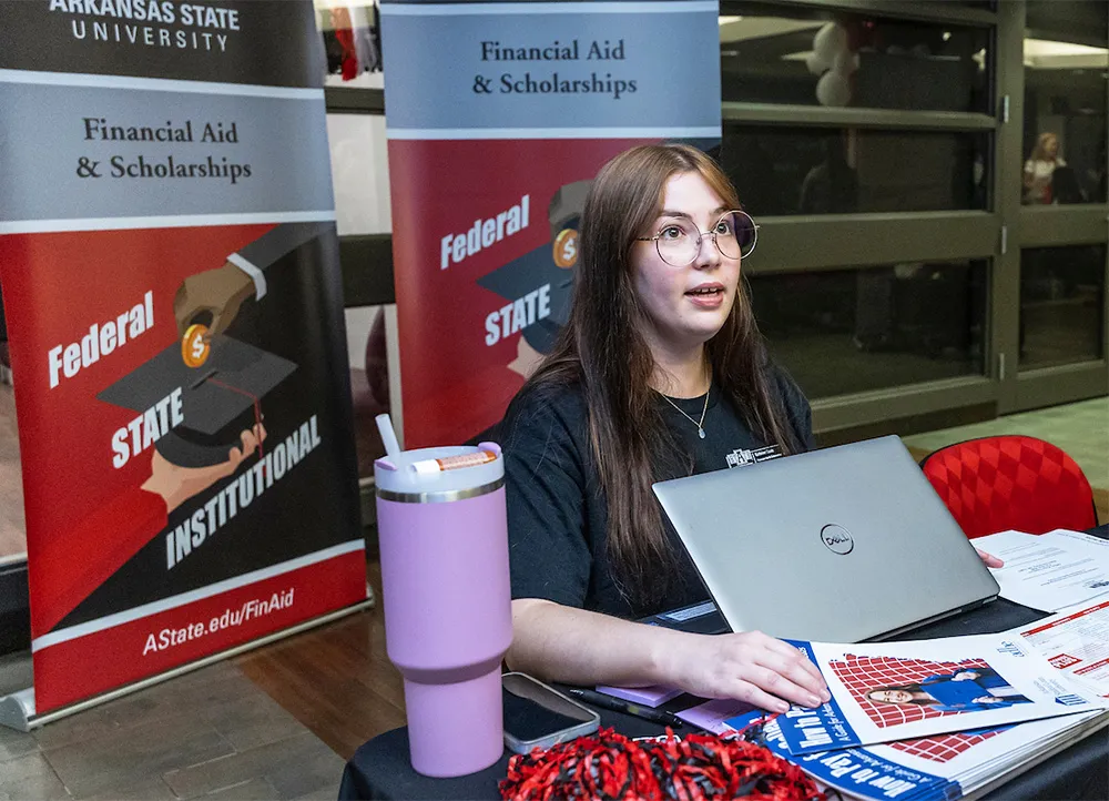 worker at a table answering financial aid questions