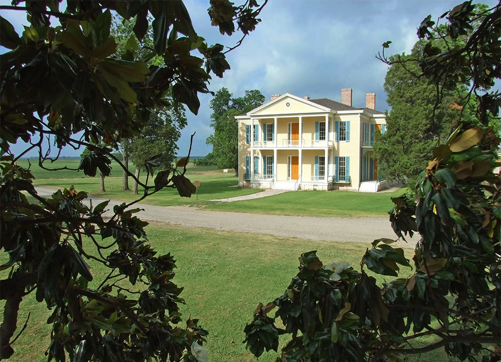 Lakeport Plantation framed by leaves.