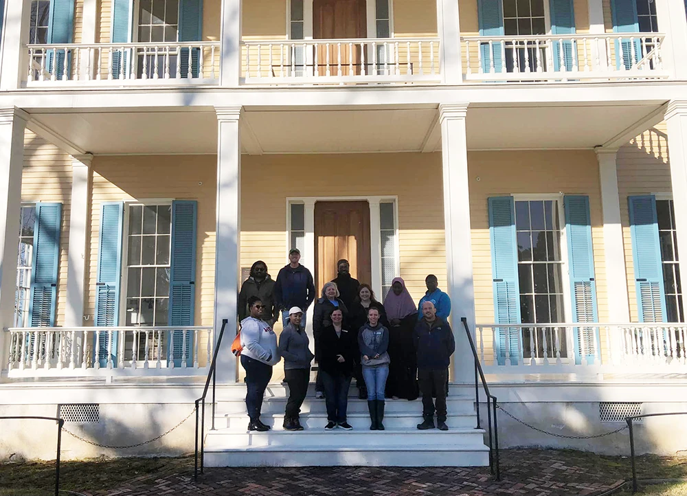 Tour group posing on porch of the Lakeport Plantation home.