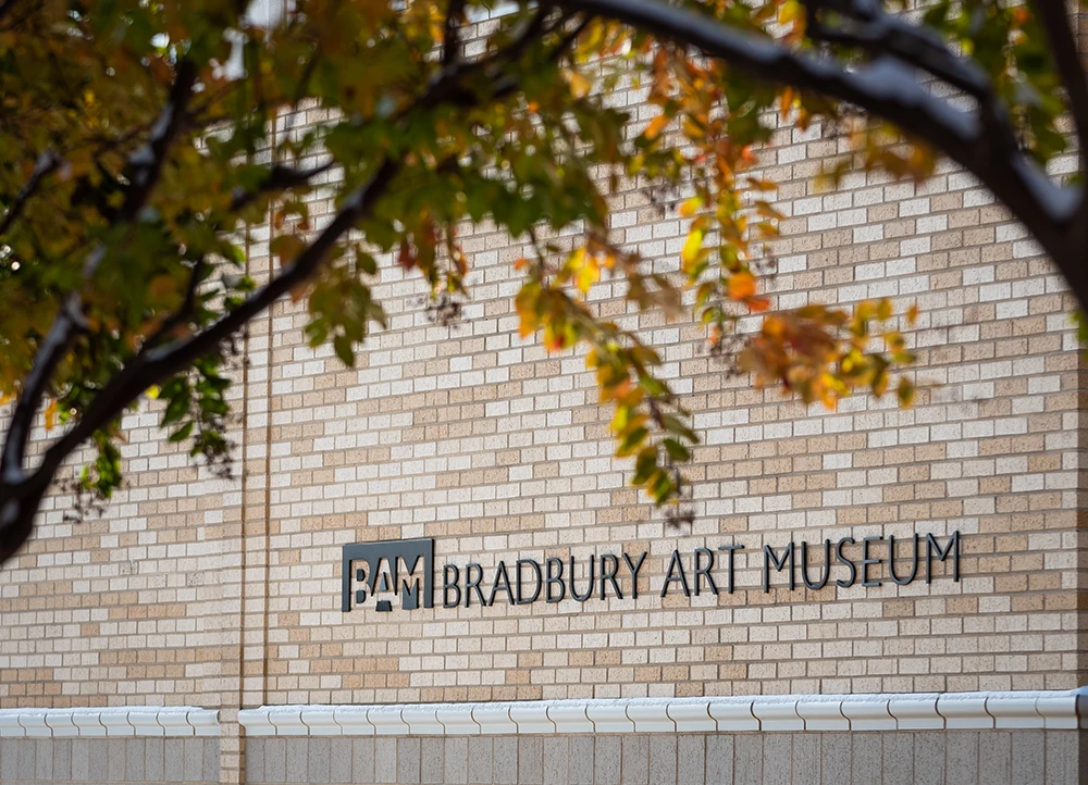 The exterior of the Bradbury Art Museum framed by autumn leaves.