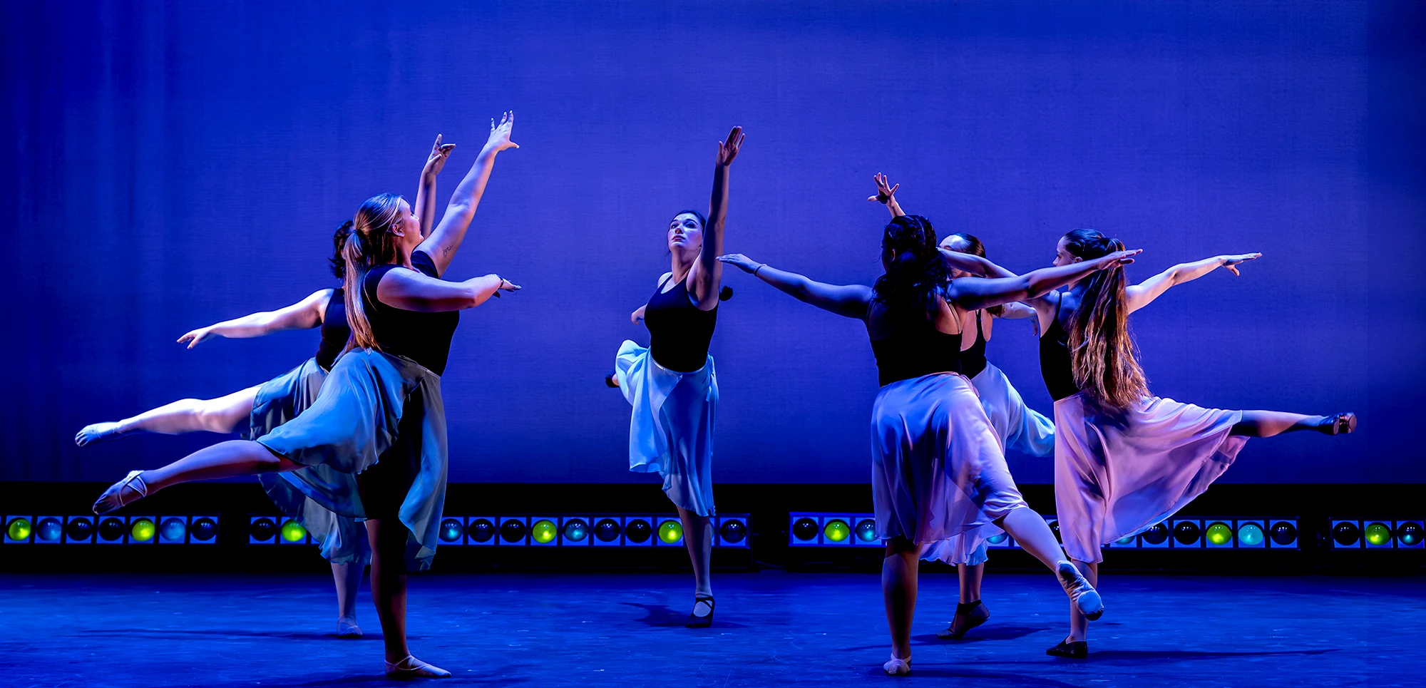 Dancers in sync while standing in a circle.