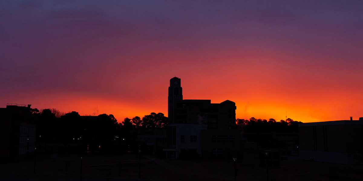 The sun rising over the Dean B. Ellis Clocktower
