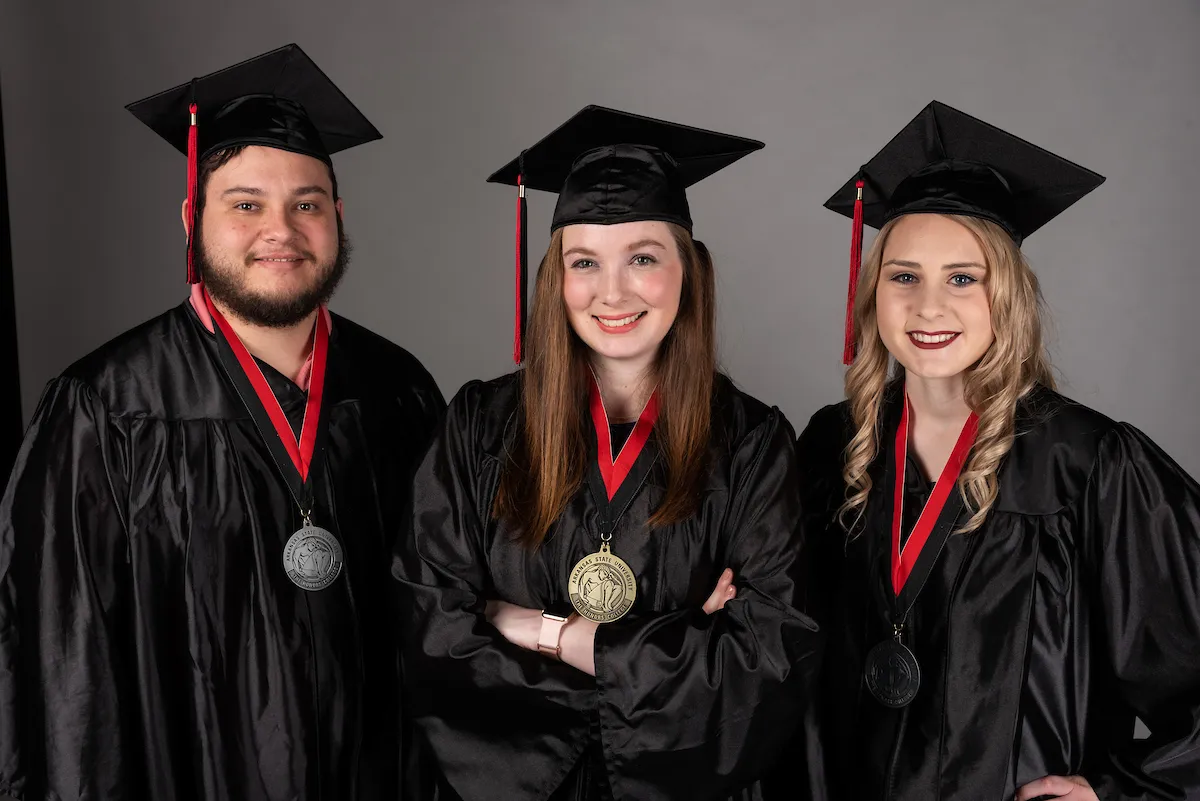 Students in graduation regalia and honors medals