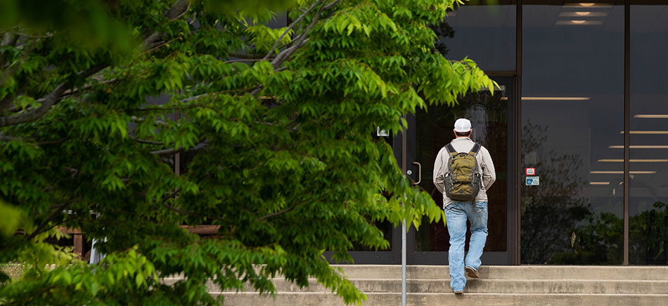 A student walking into the College of Agriculture