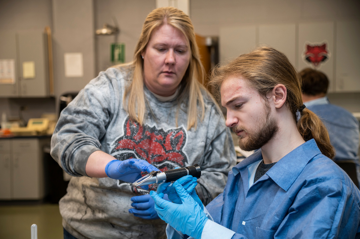 Student and teacher working side by side in the lab.