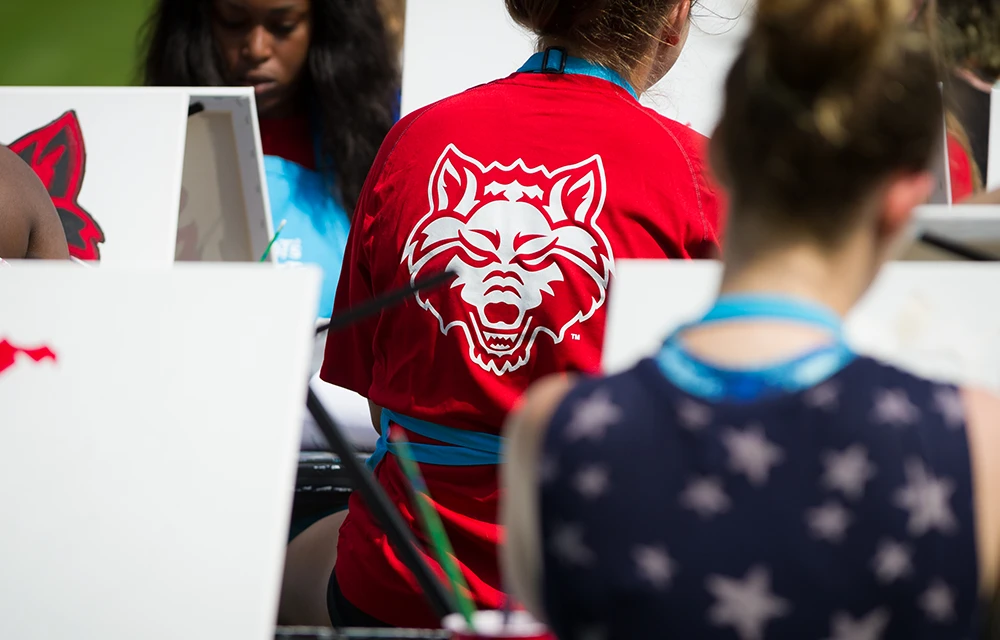 Close-up of back of student's Red Wolves shirt while they're painting.