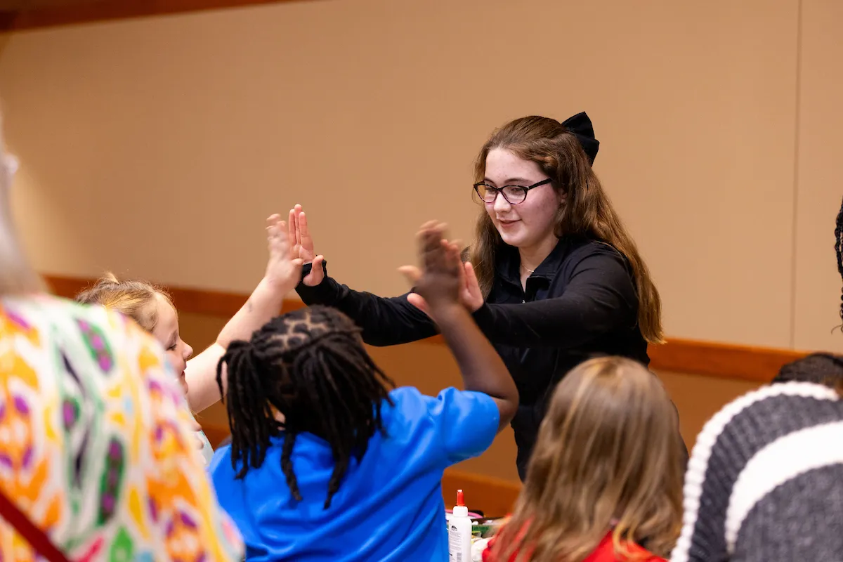 A student high fives a group of children